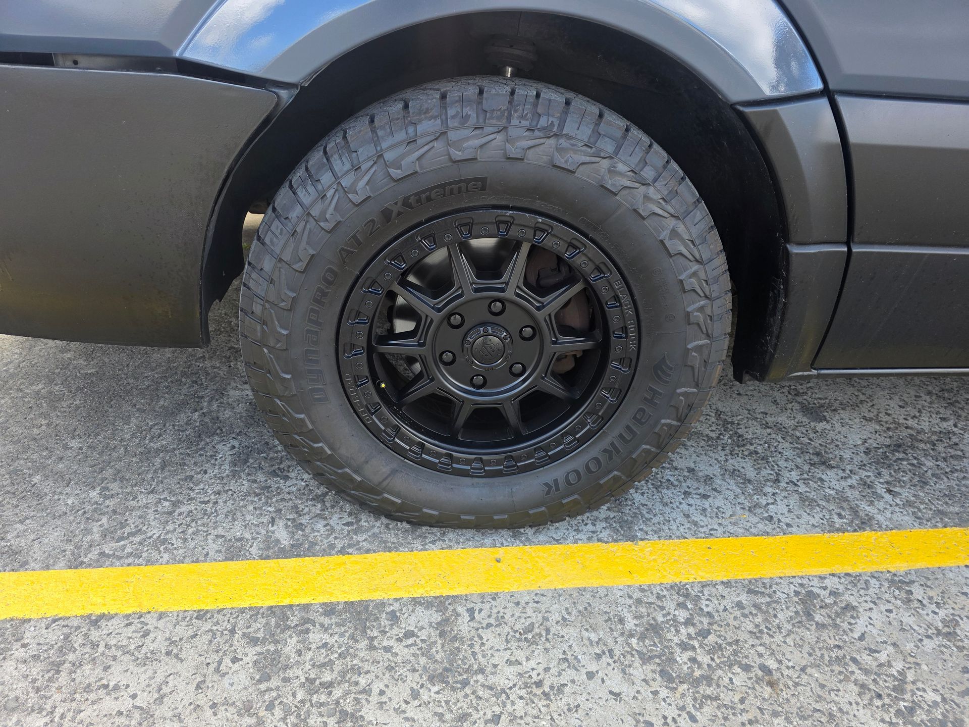 Black Vehicle Wheel on Pavement with A Yellow Line — Autoplus Picton in Picton, NSW