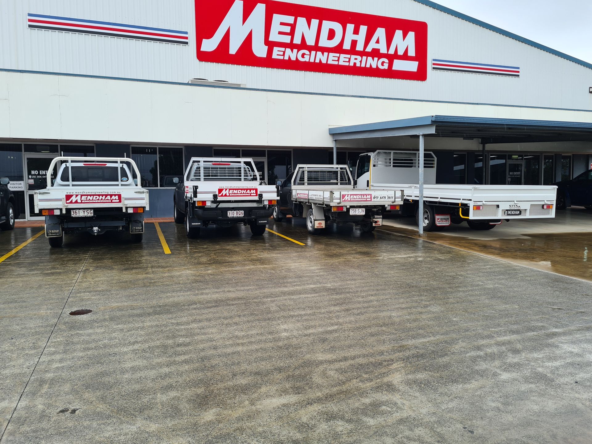 A row of trucks parked in front of a building that says mendham — Brisbane, QLD — Mendham Engineering Pty Ltdengineering