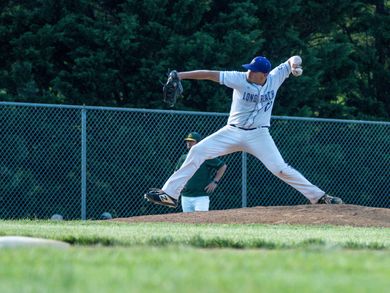 Baseball player sliding into home plate, catcher in front. Blue and gold uniforms, action shot.