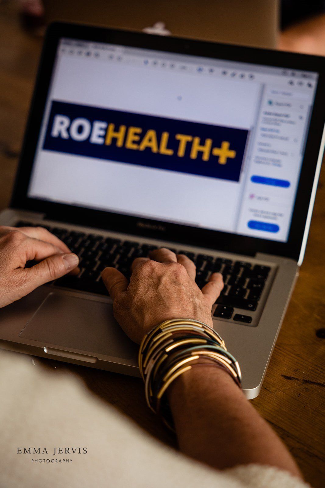 a person is typing on a laptop with the roehealth logo on the screen .