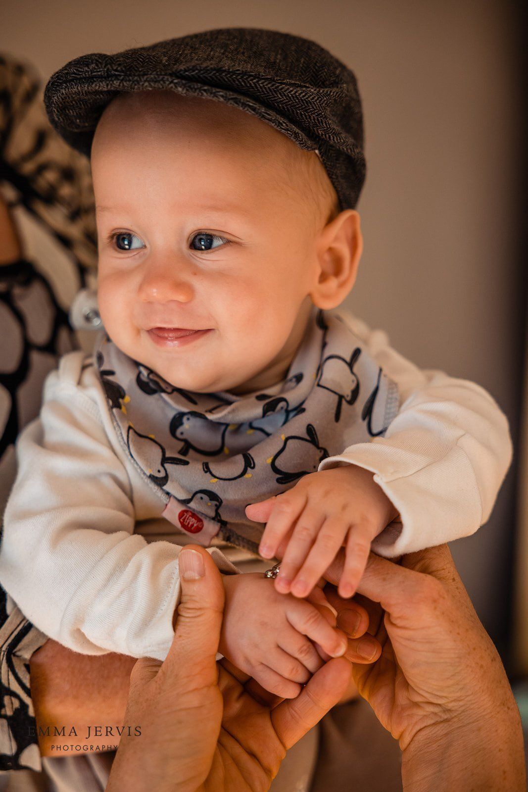 a baby wearing a hat and scarf is being held by a person .