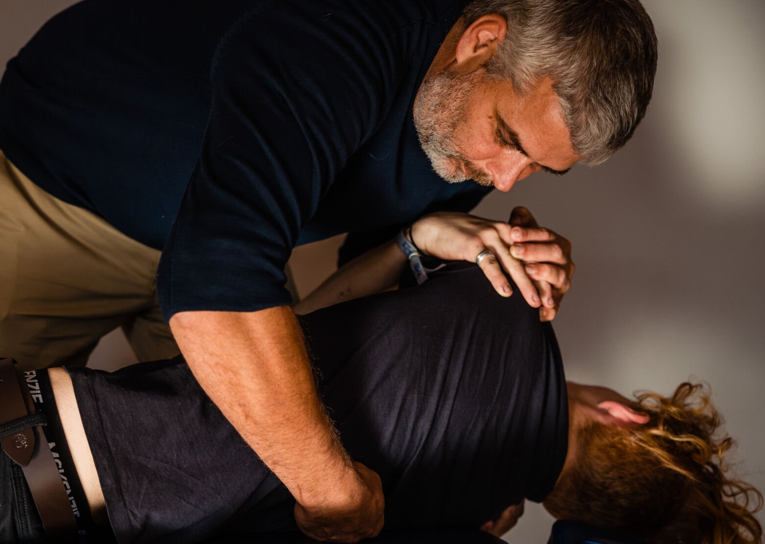 a man in a black shirt is giving a woman a massage