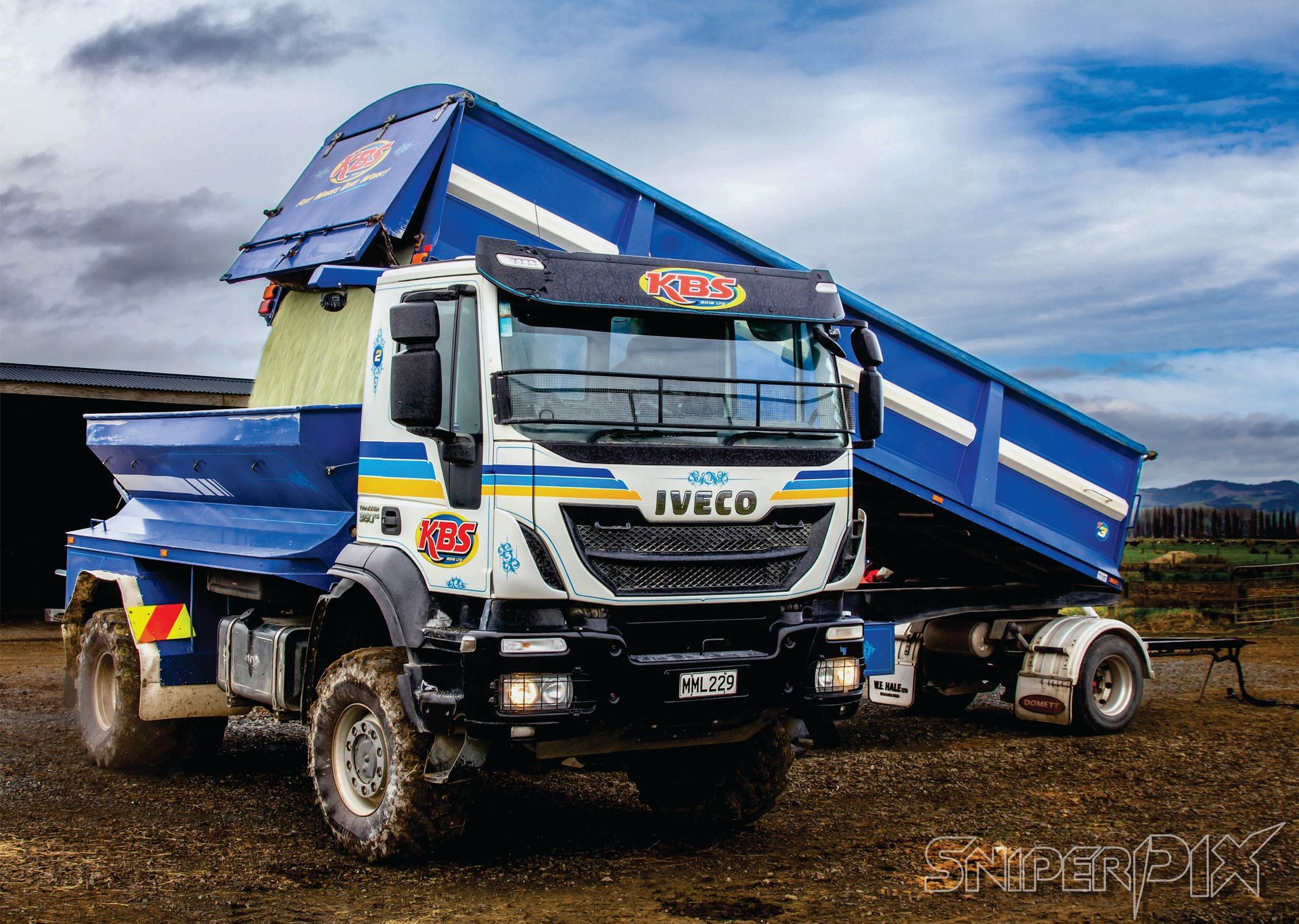 A tractor is spraying fertilizer on a lush green field.