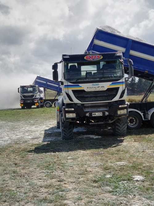 A tractor is digging a trench in the dirt in a field.