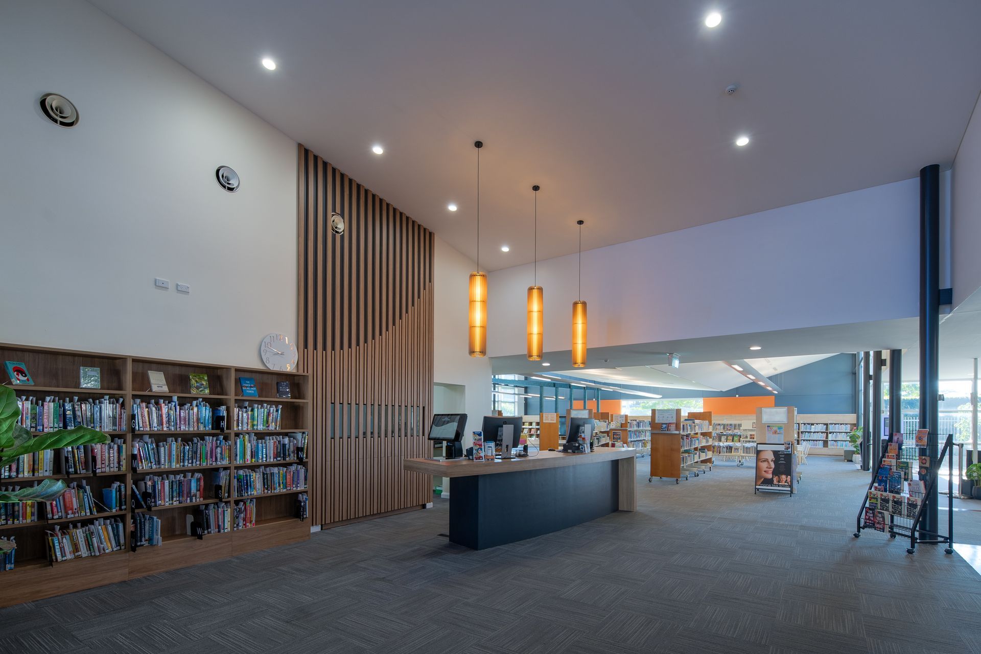 A library with a desk and shelves filled with books.