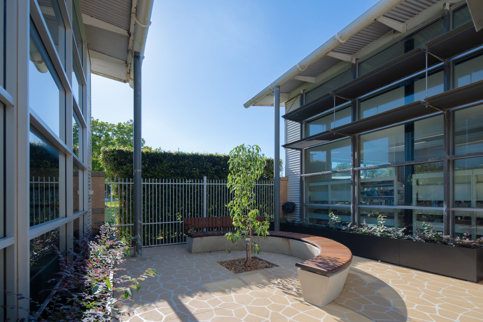 A building with a bench and a tree in front.