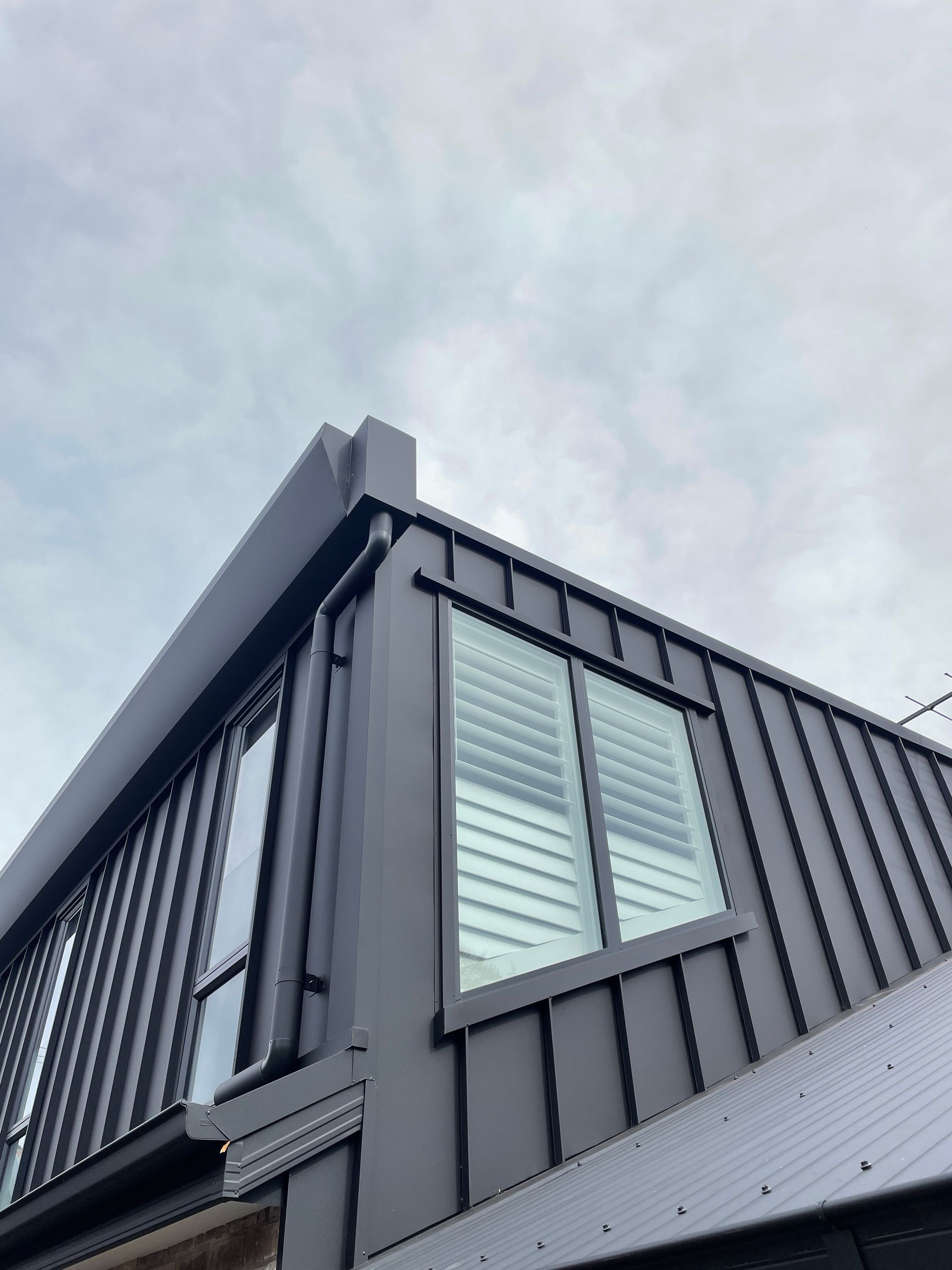 The roof of a building with windows and shutters.