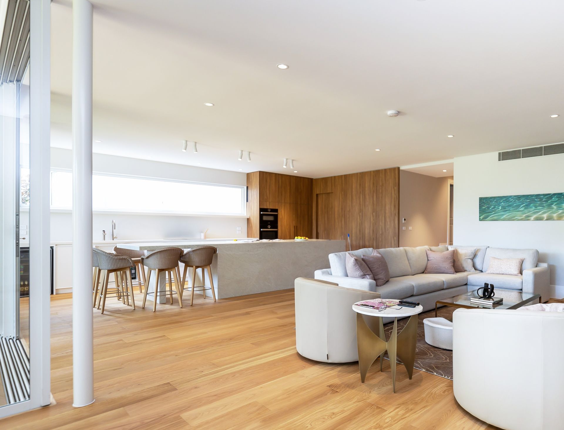 A living room with a couch, chairs, and a table.