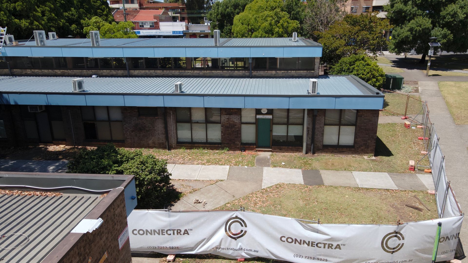 An aerial view of a building with a Connectra banner in front.