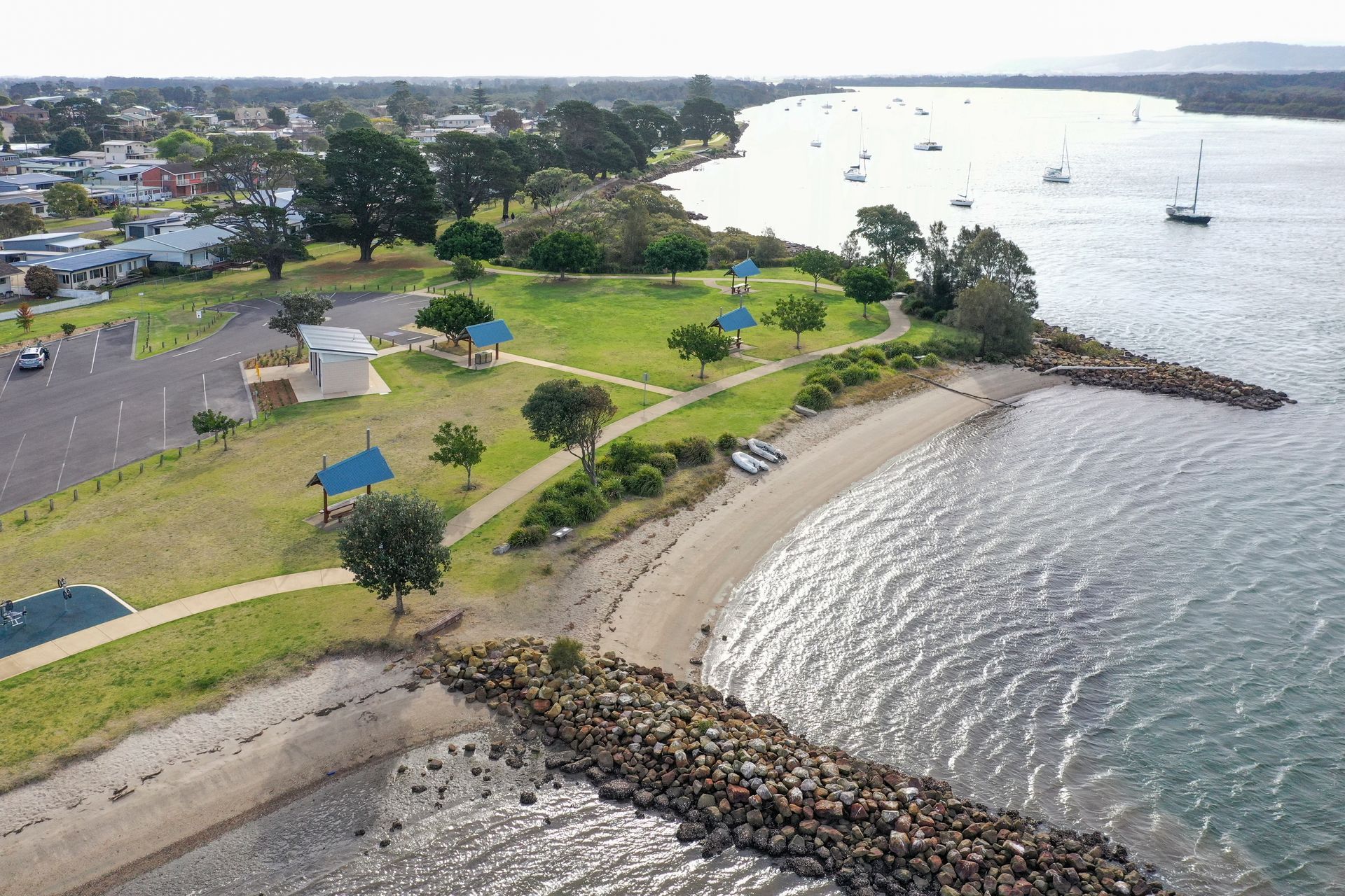 An aerial view of a park next to a body of water.