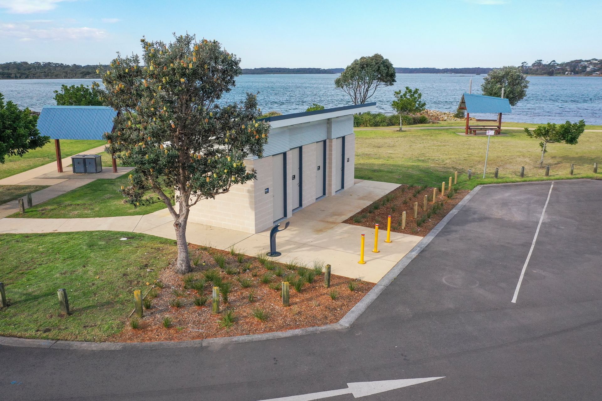 An aerial view of a park with a lake in the background.
