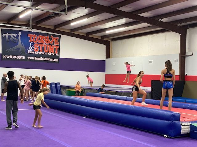Tumble and Stunt gym with students practicing on a tumble track and trampolines