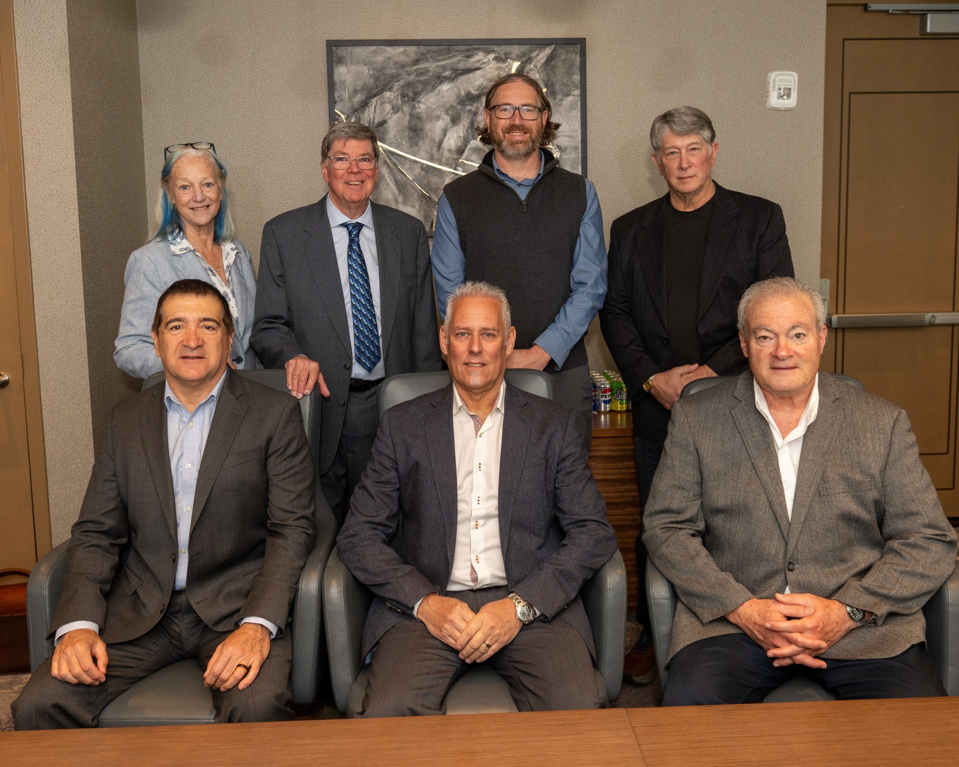 A group of people are posing for a picture in ameeting room.