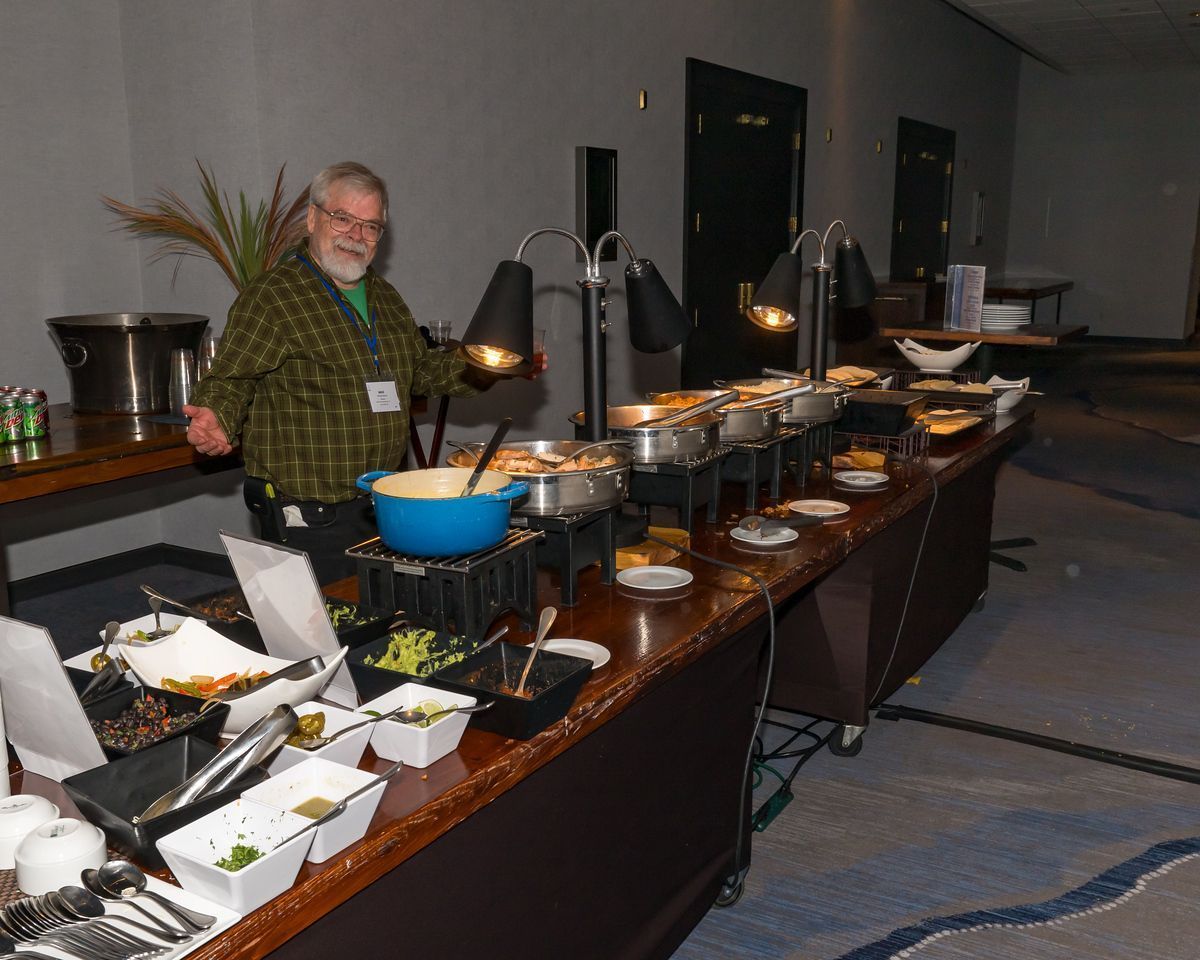 A man is standing in front of a long buffet line