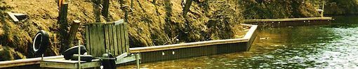 Wooden docks along the water's edge, greenery in the background.