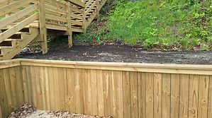 Wooden retaining wall and stairs leading up a hillside.