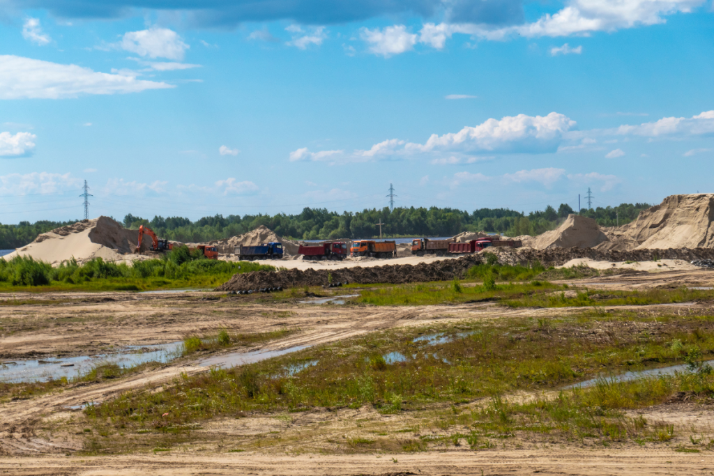 A train is going down a dirt road in a muddy field.