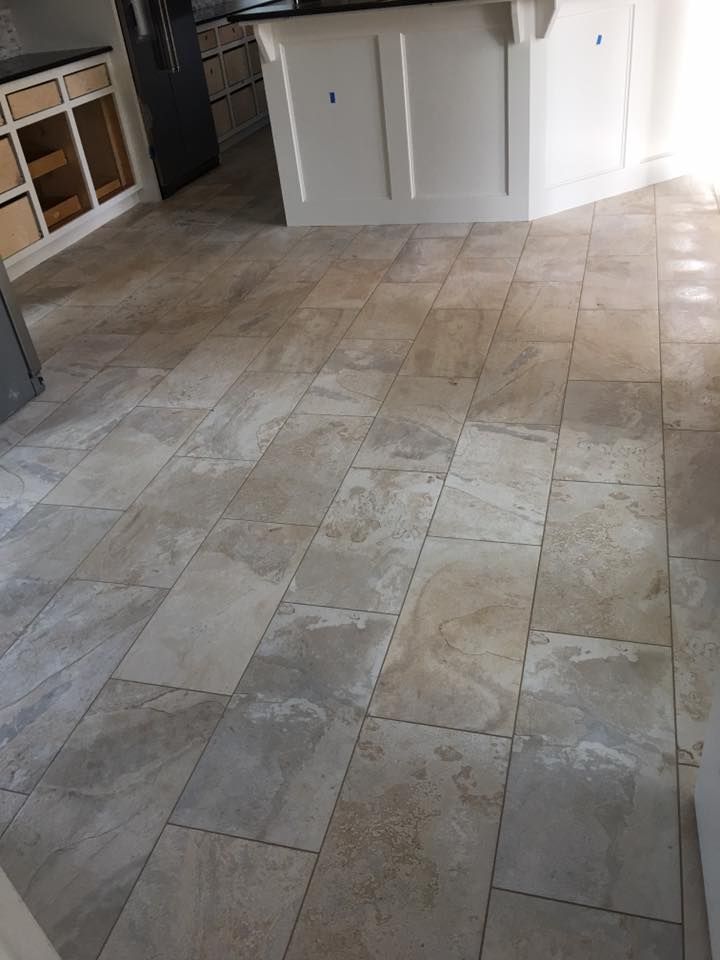 A kitchen with a tile floor and white cabinets.