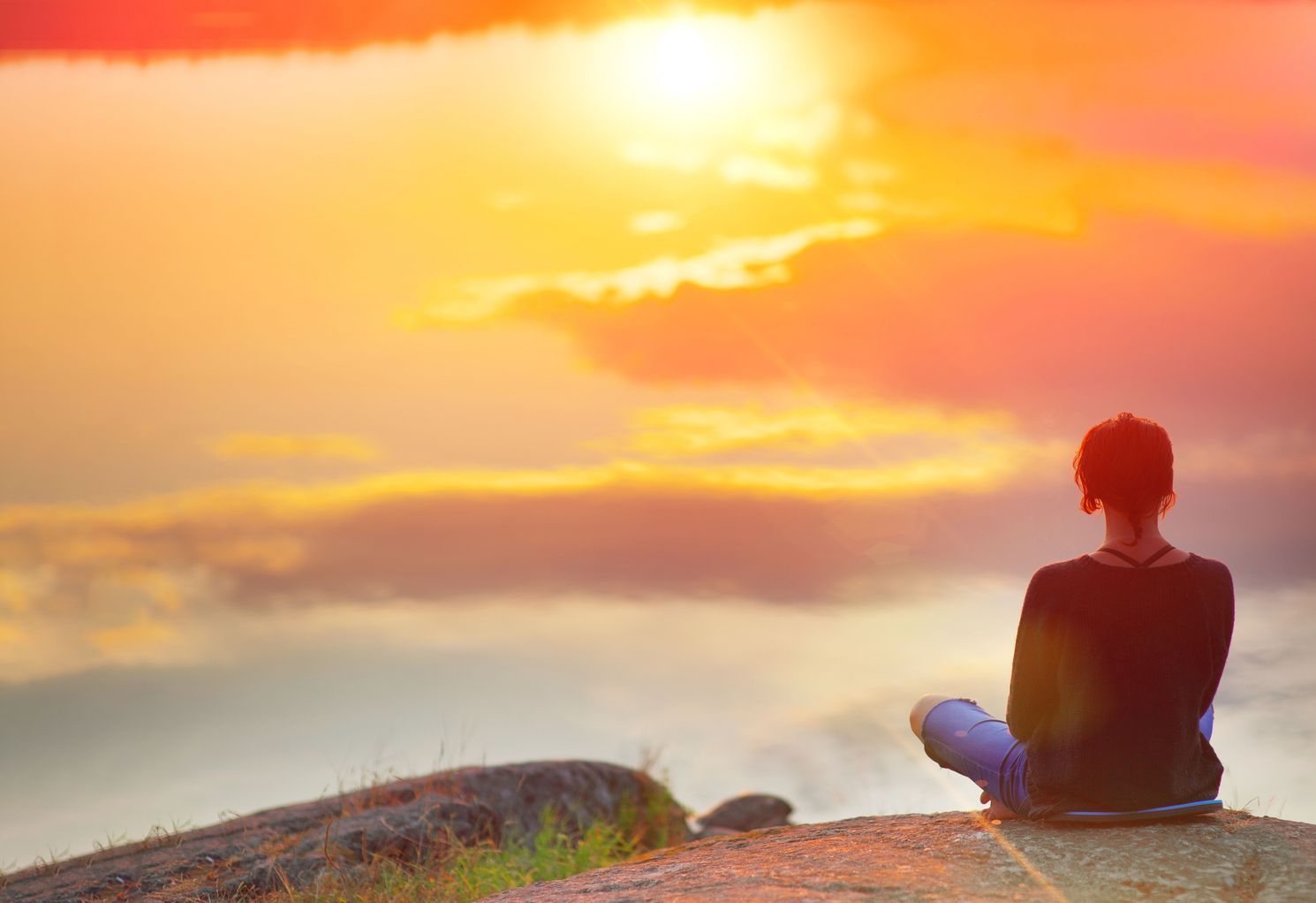 Beautiful woman sits in a pose of a lotus on high place with amazing view of the lake sunset practice yoga meditation Kundalini energy mindset intuition prana
