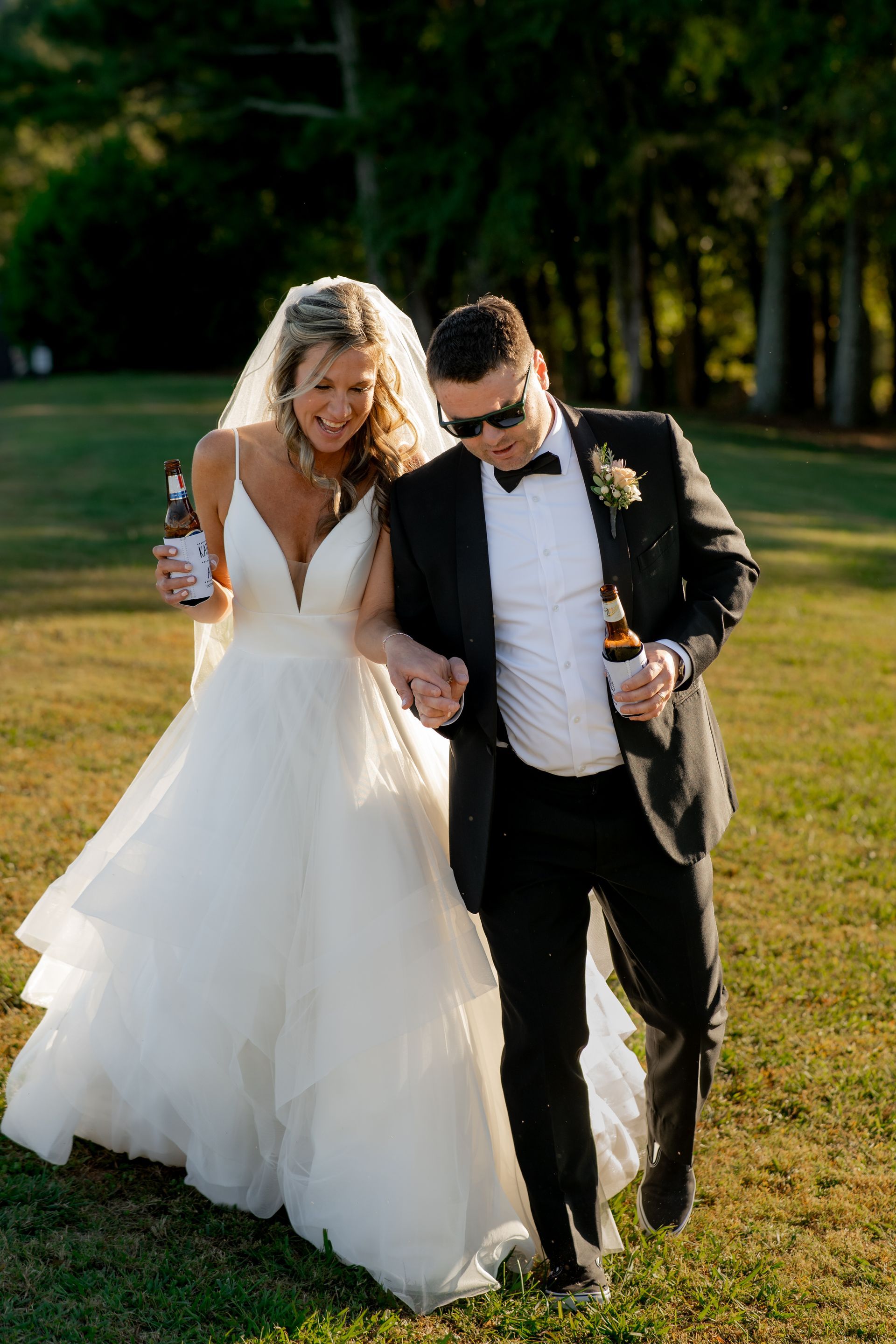 Chattanooga bride and groom holding beer and walking together at Ocoee Crest. Photographed by a Chattanooga Wedding Photographer
