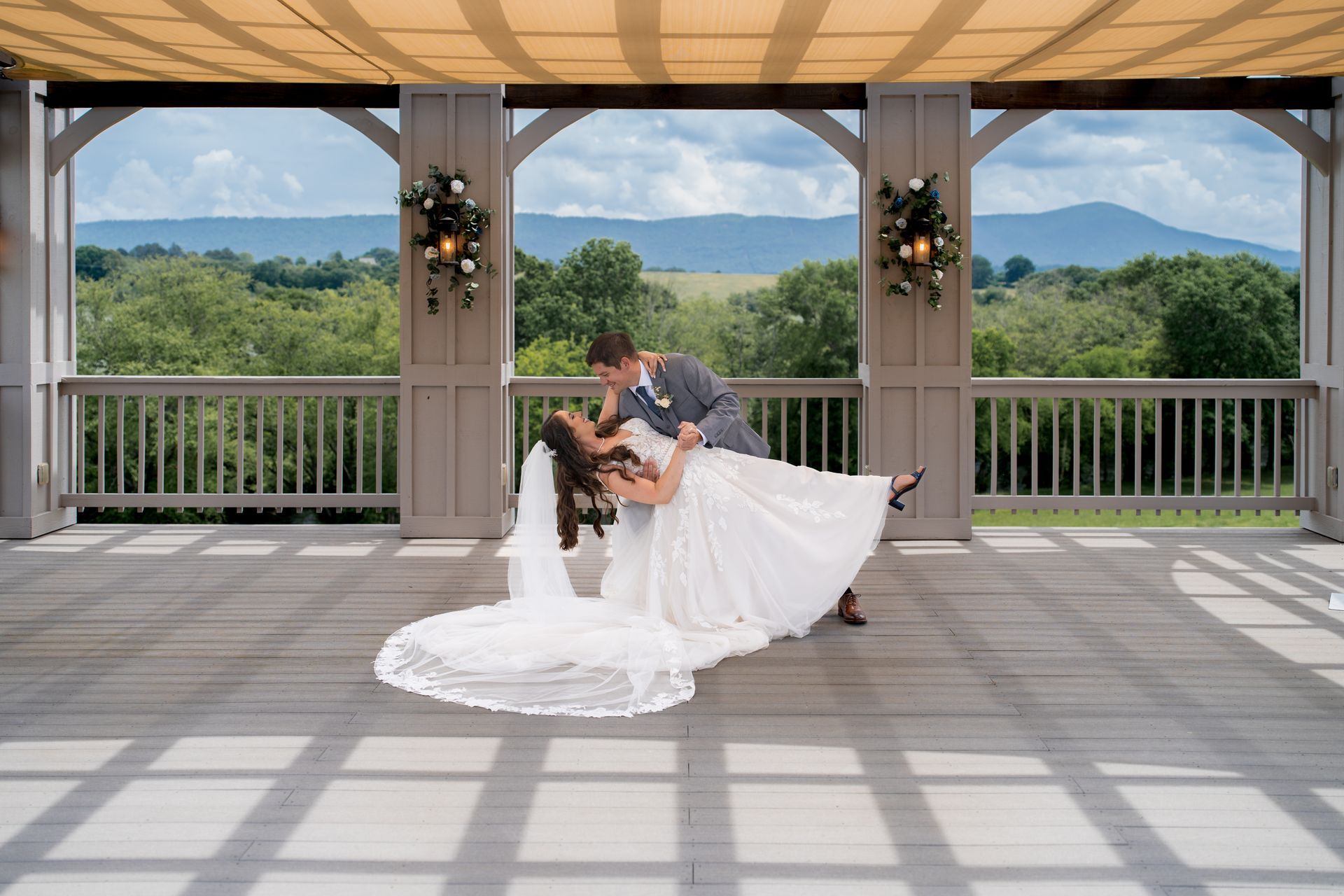 Chattanooga bride and groom doing a dip at the ceremony site with mountains in the background. Photographed by a Chattanooga Wedding Photographer