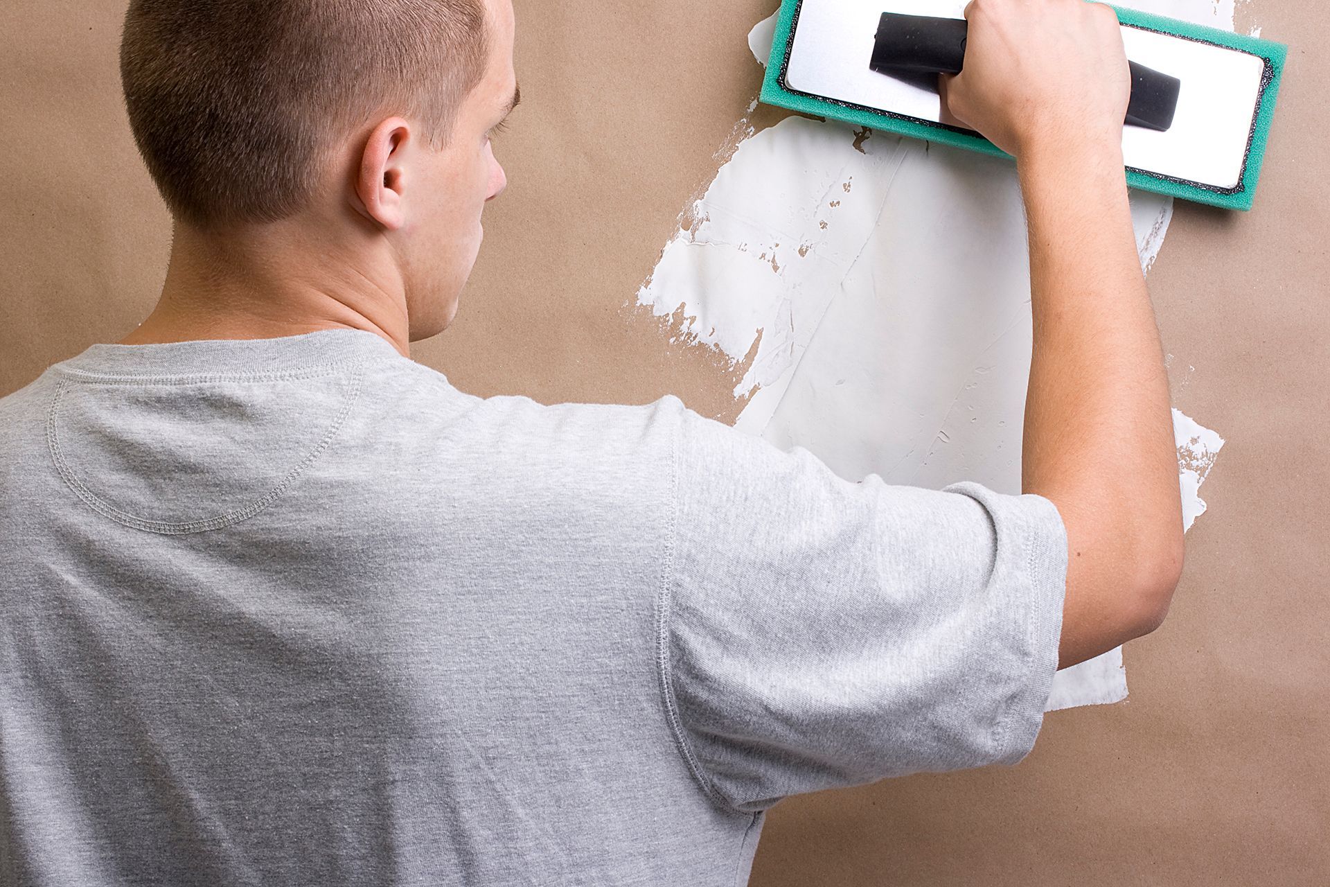 a man is plastering a wall with a spatula