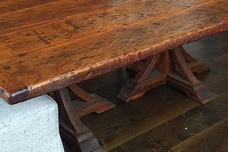 Wooden table with dark brown finish, sturdy trestle base, indoors