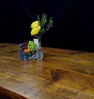 Wooden table with a glass bowl of fruit and a vase of flowers