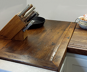 Wooden kitchen countertop with knives, pan, and bowl
