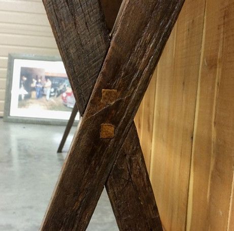 Close-up of rustic wooden table legs crossed, joined with wooden pegs