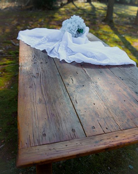 Wooden table with white cloth and flowers outside