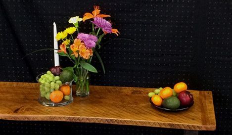 Wooden table with flowers, fruit, and a candle