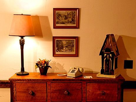 A wooden dresser with a lamp