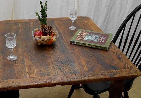 Wooden table with a book, glasses, and bowl of fruit