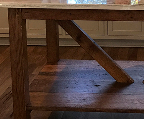 Wooden table with marble top and angled support beam
