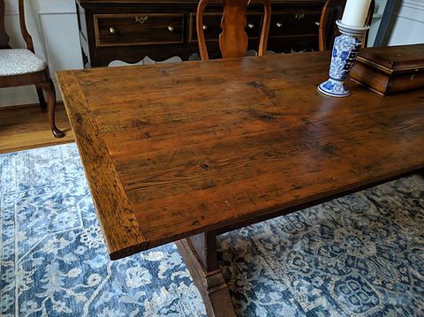 Wooden dining table with decorative rug, furniture, and candleholder