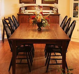 Dining room with a wood table, black chairs, and a floral centerpiece