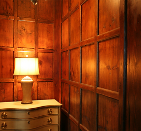 Wooden paneled room with a lamp on a dresser