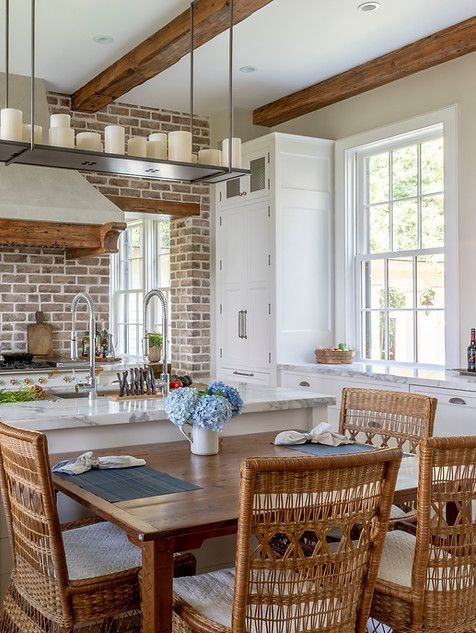 Kitchen with brick backsplash, white cabinets, and wooden beams