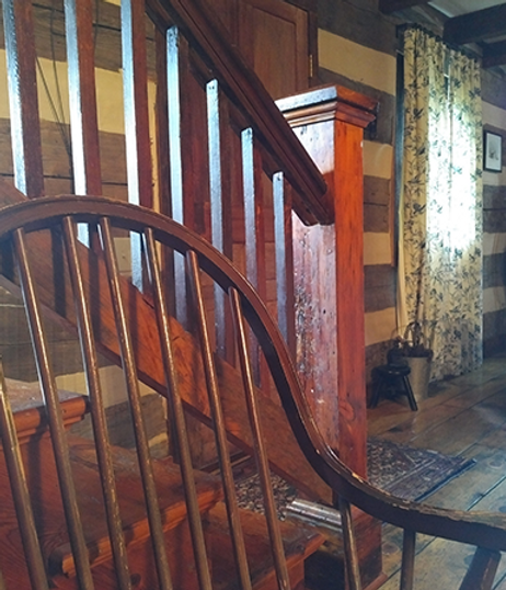 Wooden staircase with a curved chair in the foreground