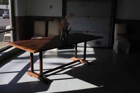 Wooden table with decorative vase, in front of a window and garage door