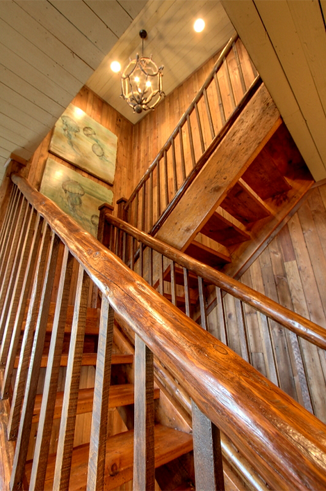 Wooden staircase with railings and detailed wood paneling