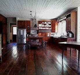 Rustic kitchen with wood floors, cabinets, and ceiling