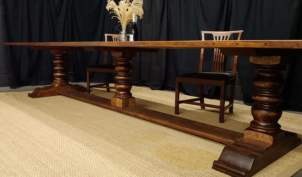Large wooden dining table with decorative supports