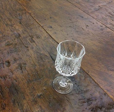 Empty crystal wine glass on a weathered brown wooden surface