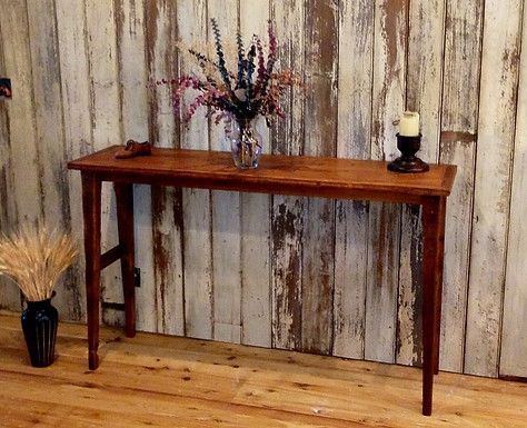 Wooden console table against a rustic, weathered wood wall