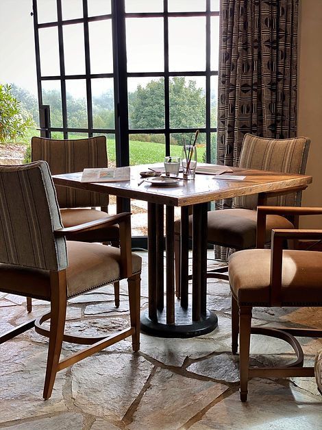 Table and chairs in front of a window overlooking a grassy area