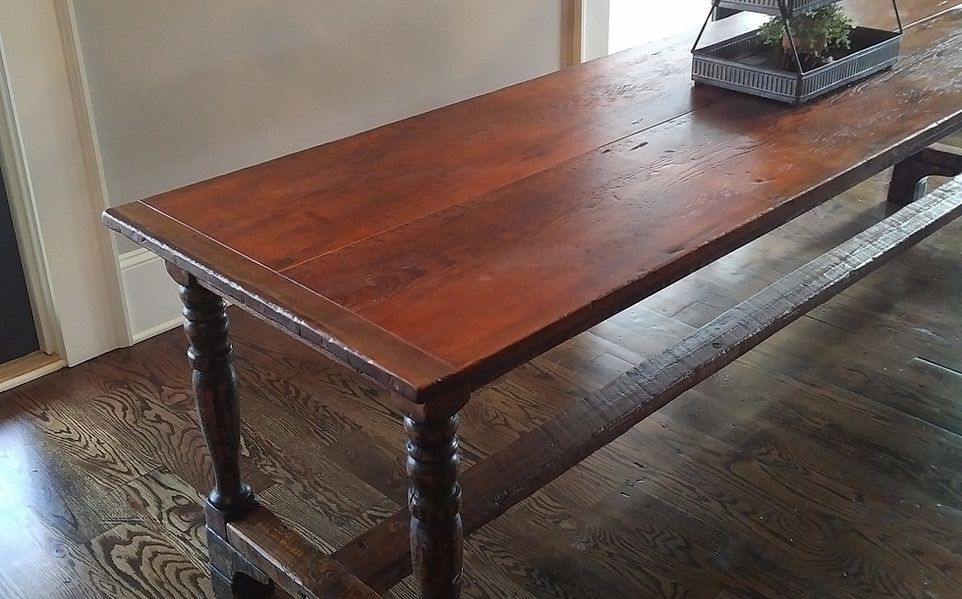 Wooden, antique-style table in a room with hardwood floors