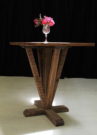 Rustic wooden table with a vase of pink flowers on top