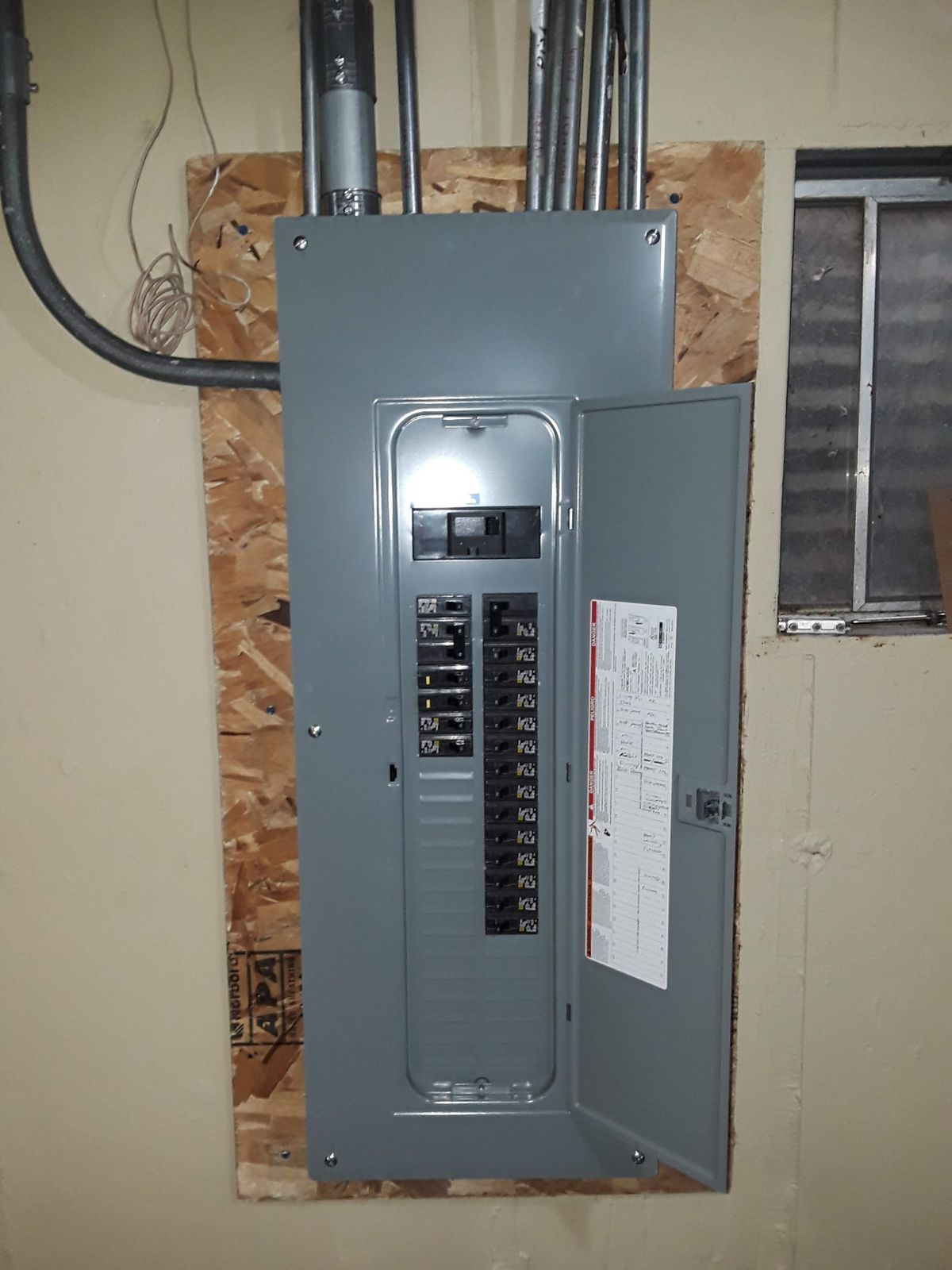 A electrical box with the door open and a warning label on it